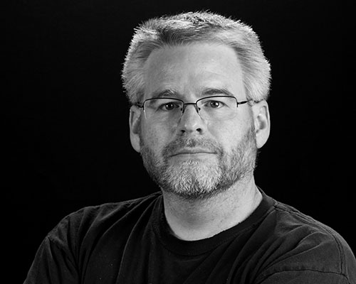 A black and white photo of Dan MacDonald, the website owner